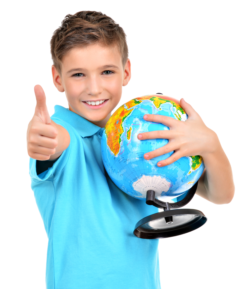 Smiling boy in casual  holding globe with thumbs up sign -  isolated on white